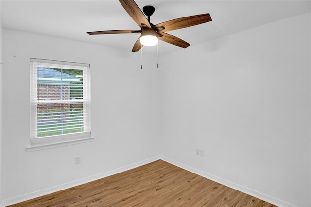 empty room featuring baseboards, ceiling fan, and light wood-style flooring