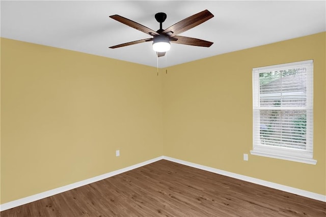 unfurnished room featuring a ceiling fan, dark wood finished floors, and baseboards