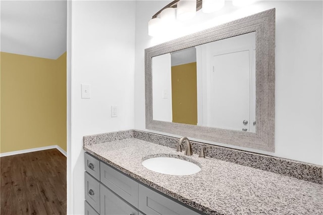 bathroom with vanity, wood finished floors, and baseboards