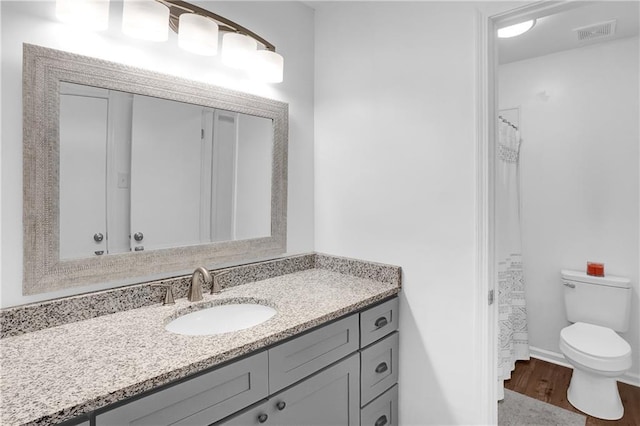 full bathroom with wood finished floors, visible vents, toilet, and vanity