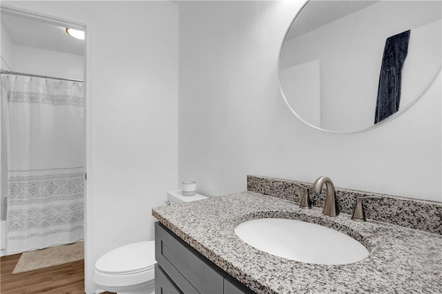 full bathroom featuring toilet, wood finished floors, and vanity
