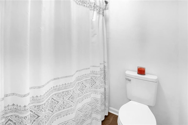full bath with baseboards, wood finished floors, and toilet