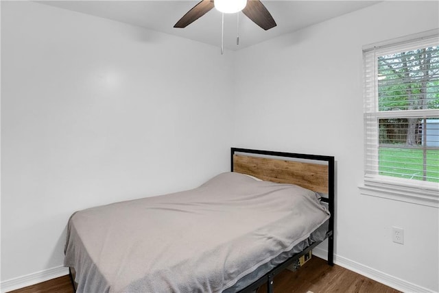 bedroom featuring a ceiling fan, wood finished floors, and baseboards
