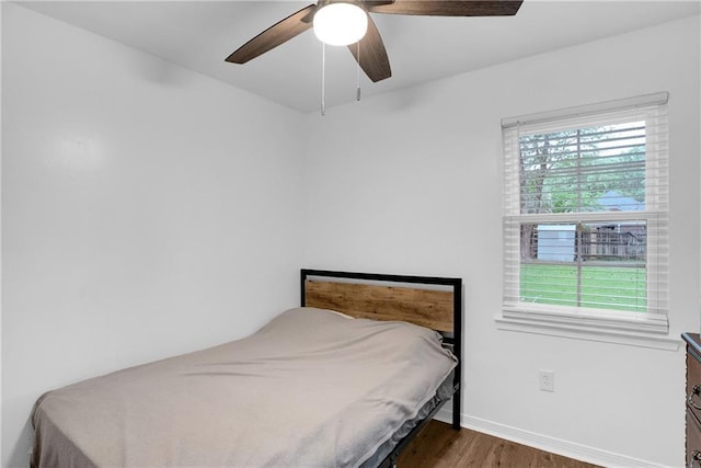 bedroom featuring a ceiling fan, wood finished floors, and baseboards