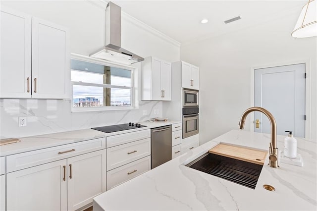 kitchen featuring island exhaust hood, backsplash, light stone countertops, white cabinetry, and appliances with stainless steel finishes