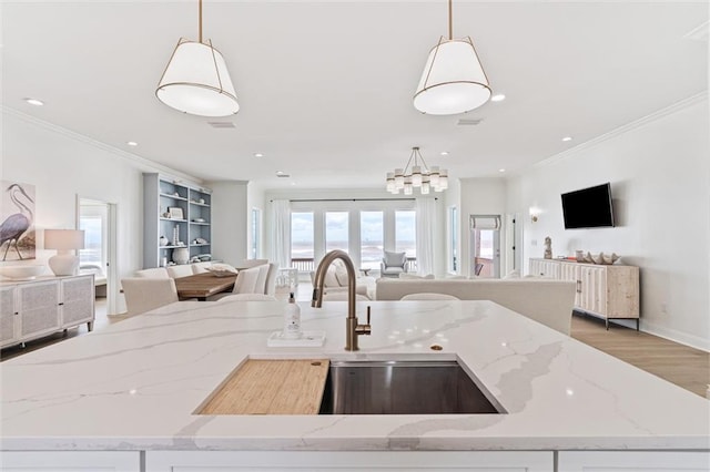 kitchen featuring pendant lighting, hardwood / wood-style flooring, and light stone countertops