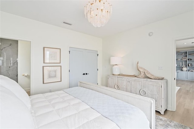 bedroom with an inviting chandelier, a closet, and light hardwood / wood-style flooring