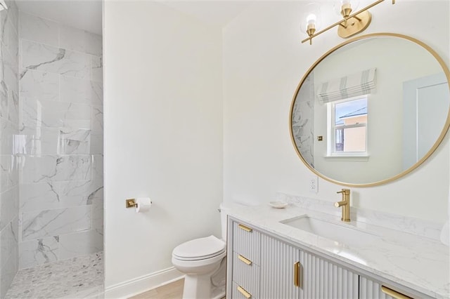 bathroom featuring vanity, toilet, and a tile shower