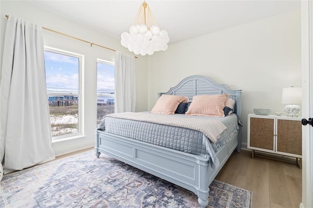 bedroom with hardwood / wood-style flooring and a chandelier