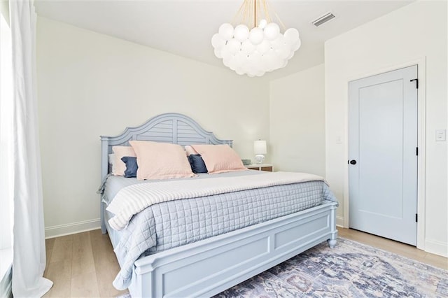 bedroom featuring an inviting chandelier and hardwood / wood-style flooring