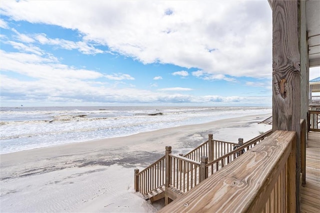 wooden deck with a view of the beach and a water view