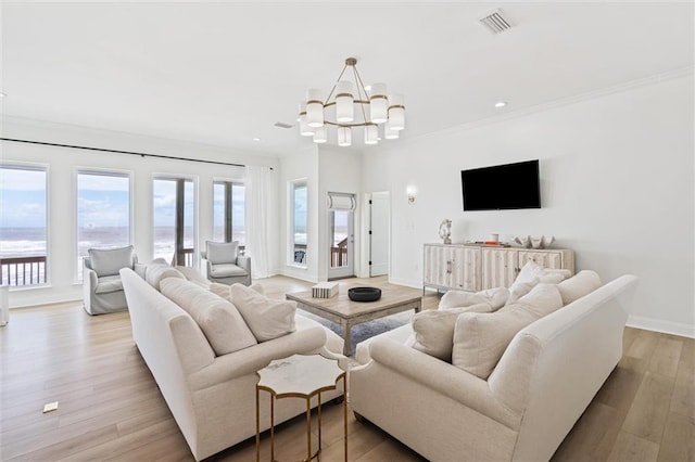 living room with light wood-type flooring, an inviting chandelier, and ornamental molding