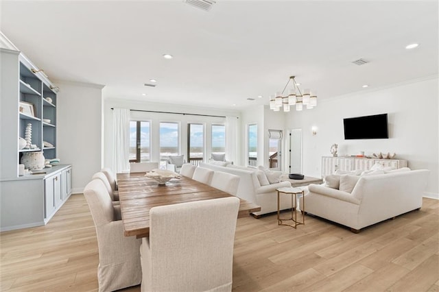 dining space with ornamental molding, light wood-type flooring, a notable chandelier, and french doors