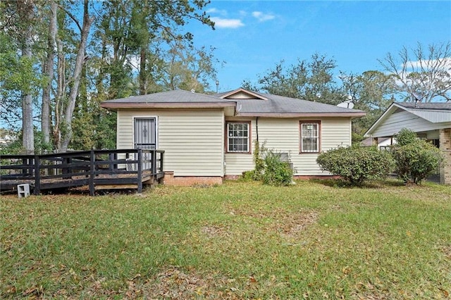 rear view of house with a yard and a wooden deck