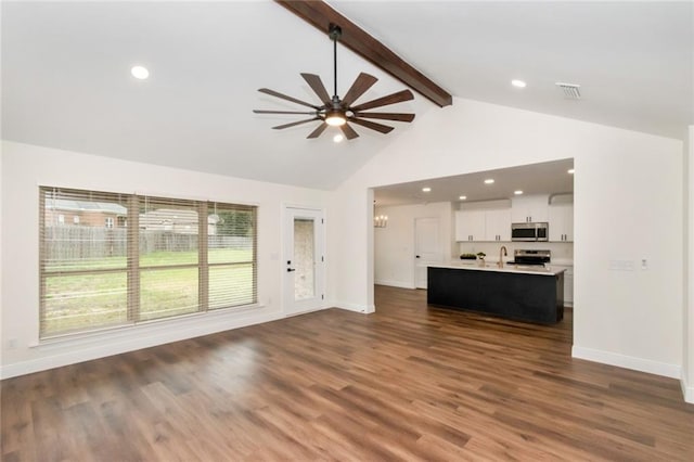 unfurnished living room featuring visible vents, beam ceiling, a ceiling fan, dark wood finished floors, and baseboards