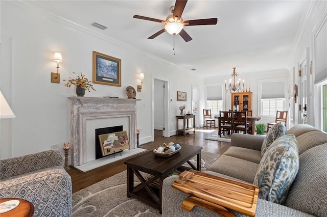 1910 Hunter Ave, Mobile, AL 36606 - living room featuring a chandelier, wood finished floors, a ceiling fan, crown molding, and a fireplace with flush hearth