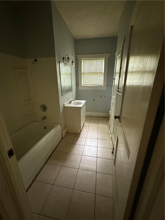 full bath featuring vanity,  shower combination, baseboards, toilet, and tile patterned flooring
