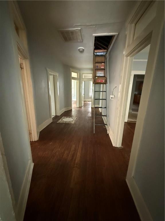 hall with dark wood-type flooring and baseboards