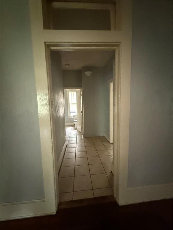 hall with tile patterned floors and baseboards