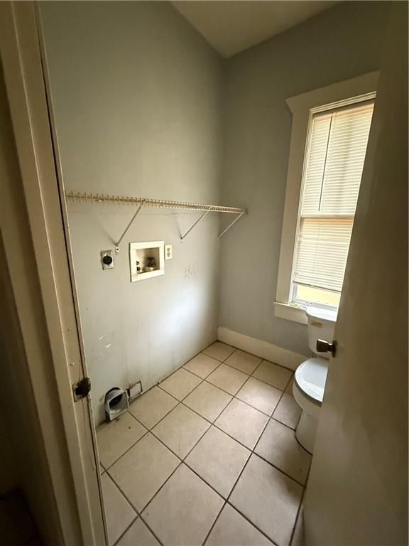laundry area with electric dryer hookup, light tile patterned flooring, hookup for a washing machine, and laundry area