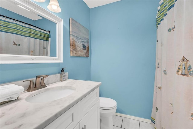 bathroom featuring toilet, tile patterned flooring, baseboards, and vanity