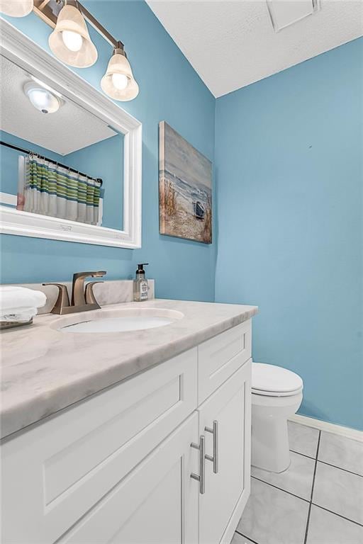 full bathroom featuring toilet, tile patterned floors, a textured ceiling, and vanity