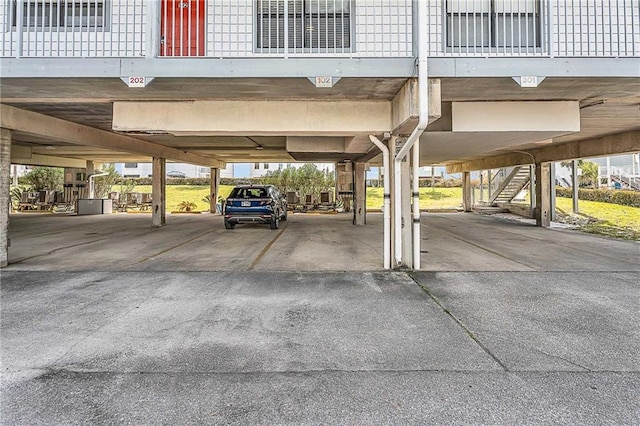 view of parking / parking lot with a carport and stairs