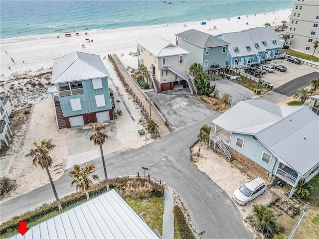 drone / aerial view featuring a view of the beach, a water view, and a residential view