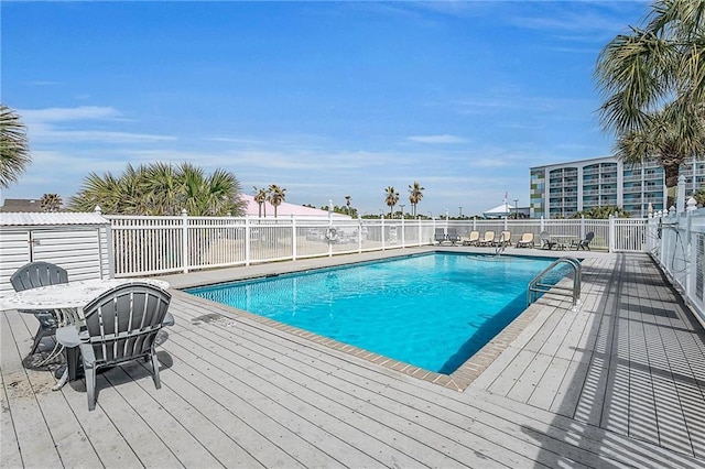 pool featuring fence and a deck