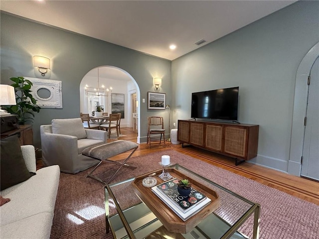 living room with hardwood / wood-style floors and a chandelier