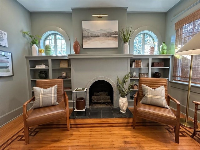 living area featuring hardwood / wood-style flooring and a tiled fireplace