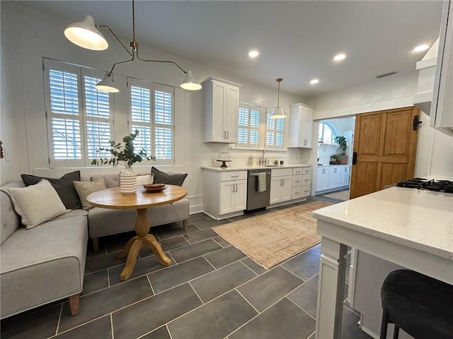 kitchen featuring decorative light fixtures, tasteful backsplash, sink, white cabinets, and stainless steel dishwasher