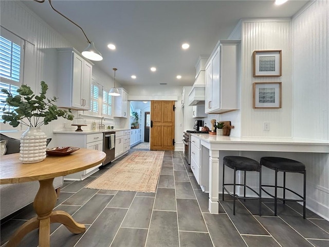 kitchen featuring plenty of natural light, stainless steel appliances, decorative light fixtures, and white cabinets