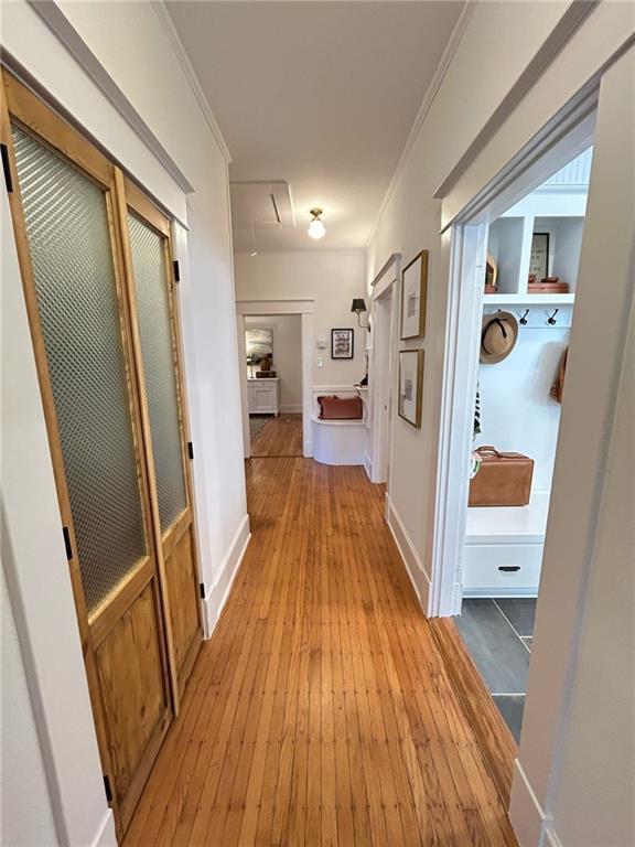 corridor featuring crown molding and light hardwood / wood-style floors