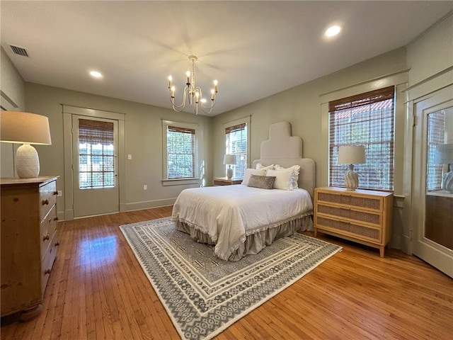 bedroom with hardwood / wood-style floors and a chandelier