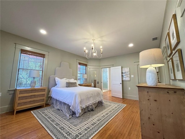 bedroom featuring hardwood / wood-style floors and a chandelier