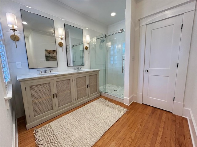 bathroom with hardwood / wood-style flooring, vanity, and an enclosed shower