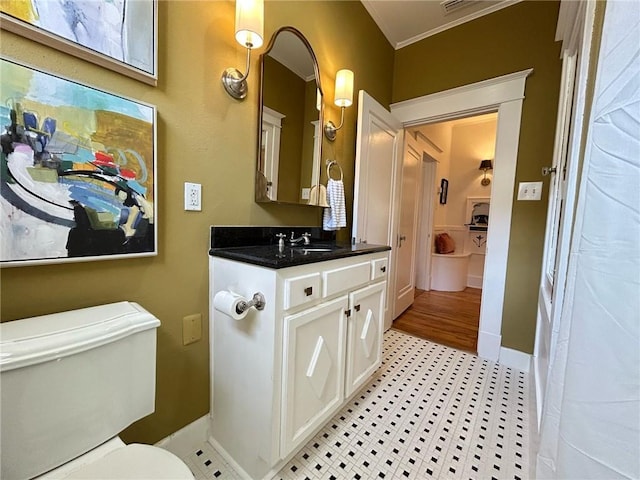 bathroom with ornamental molding, vanity, toilet, and tile patterned floors