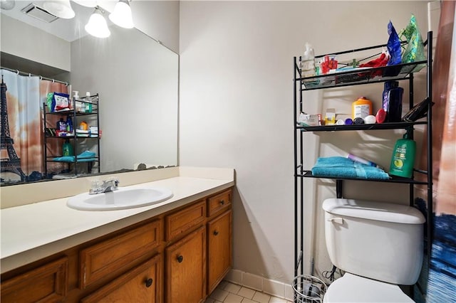 bathroom featuring toilet, vanity, and tile patterned flooring