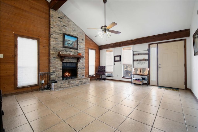 unfurnished living room with beam ceiling, high vaulted ceiling, wood walls, light tile patterned floors, and a brick fireplace