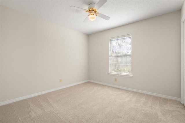 empty room featuring light colored carpet and ceiling fan