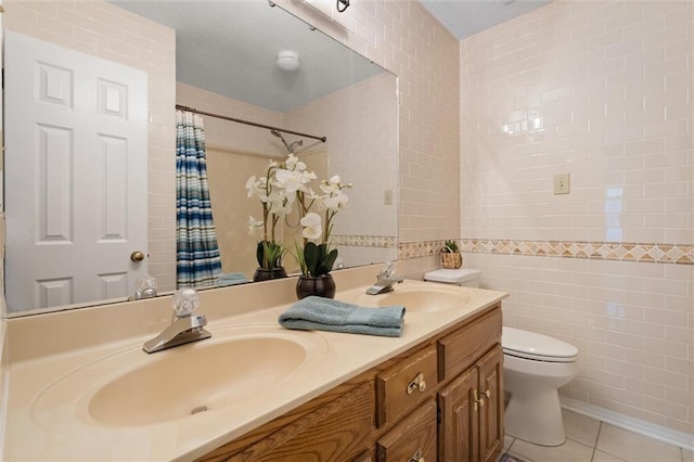 bathroom with vanity, toilet, tile patterned flooring, and tile walls