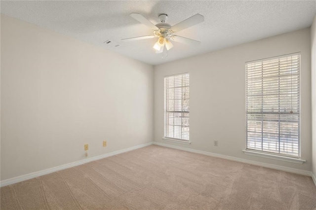 carpeted empty room featuring a textured ceiling and ceiling fan