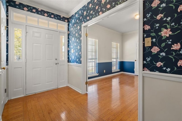 foyer entrance featuring crown molding and light wood-type flooring