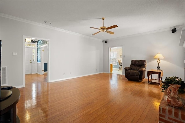 living area featuring crown molding, ceiling fan, and light wood-type flooring