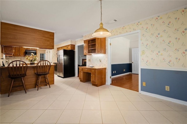 kitchen featuring tasteful backsplash, appliances with stainless steel finishes, decorative light fixtures, and light tile patterned flooring