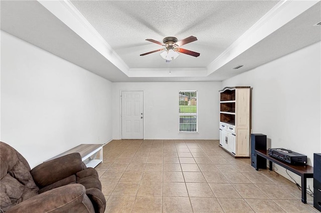 living room featuring a tray ceiling, a textured ceiling, light tile patterned floors, and ceiling fan