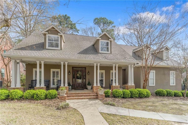 view of front facade featuring a porch, stucco siding, and a shingled roof