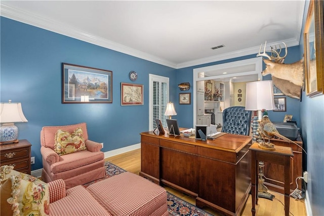 office area with wood finished floors, ornamental molding, and baseboards