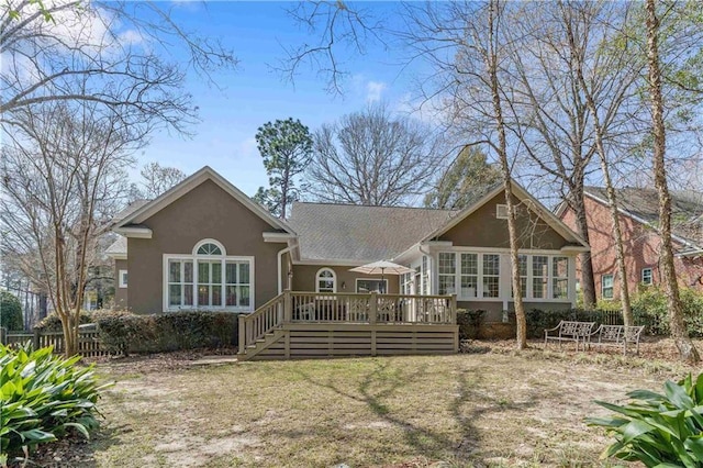 back of property with stucco siding and a deck